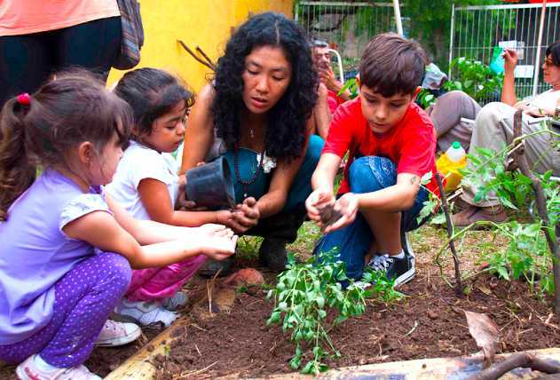 Crianças aprendendo a importância de respeitar a natureza em evento na praça