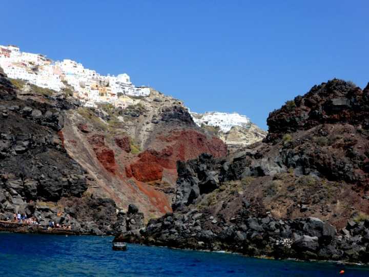 O contraste de Oia no topo das rochas vulcânicas