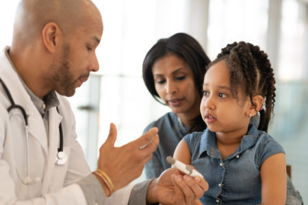 médico negro atendendo uma criança e sua mãe