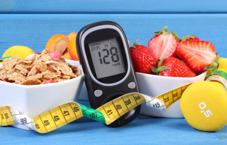 Medidor de glicose com o nível de açúcar, alimentos saudáveis, halteres e fita métrica