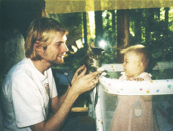 Kurt Cobain, aos 26 anos, mostrando um gatinho à sua filha