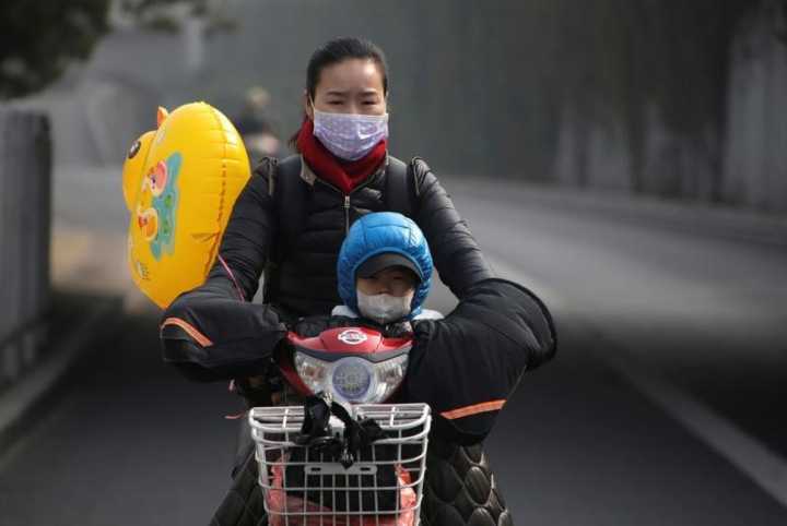 Mulher e criança usam máscaras por conta da poluição em Pequim. 04/11/2016
