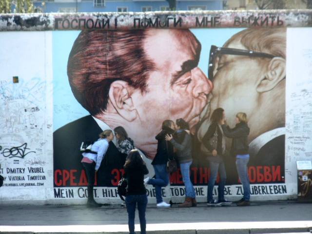 Turistas imitam a arte do Muro de Berlim