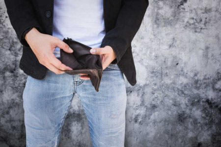 Empty black wallet in the hands of a freelancer on concrete background.