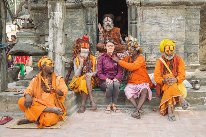 Turista com grupo de sadhus, hindus que vivem exclusivamente para meditar