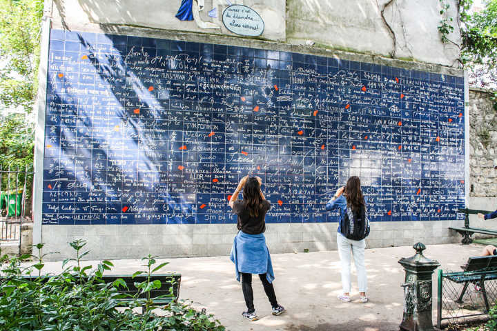 Turistas tiram foto do Le Mur des Je t’aime (o Muro dos Eu Te Amo) , que fica em um pequeno jardim na Place des Abbesses