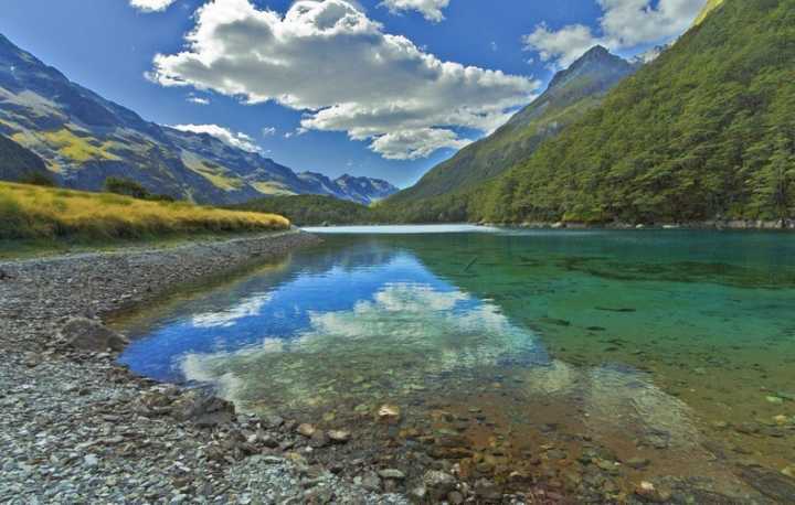 O lago Azul, na ilha Sul, na Nova Zelândia, é caracterizado por tons azul-violeta vistos apenas em águas naturais tão claras