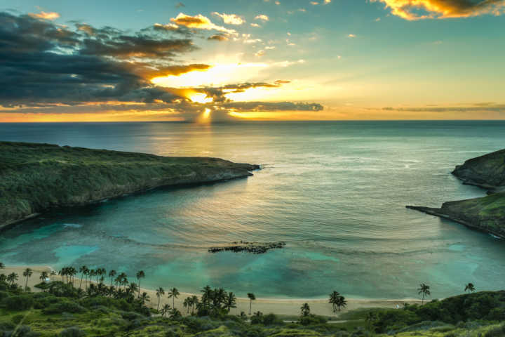 pô do sol na baía Hanauma, em Oahu; abril, maio, setembro e outubro são os melhores meses para se hospedar no Havaí, a economia média é de 20%