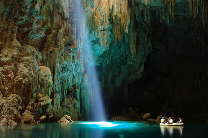 Interior do abismo Anhumas iluminado por raios solares através de claraboia natural