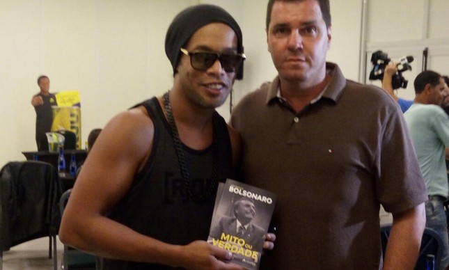 Ronaldinho Gaúcho posa com livro de Bolsonaro em mãos