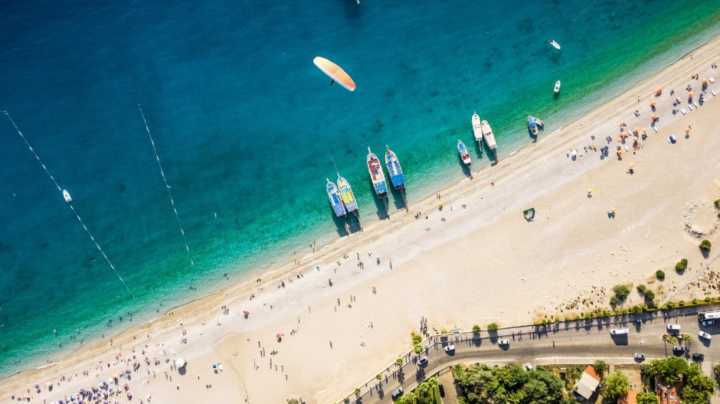 O balneário de Oludeniz é famoso pela Blue Lagoon (Lagoa Azul), um lago de água azul e cristalina que fica em área de preservação. Na praia é possível aproveitar os voos de paraglider e praticar esportes aquáticos nas calmas águas