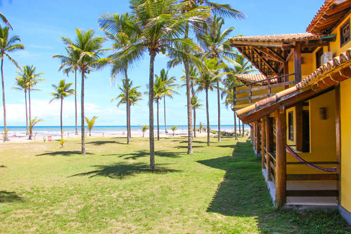 Estrutura do resort: piscinas, jogos, coqueiral e quartos na beira do mar