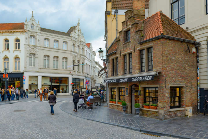 Turistas caminham por rua no centro de Bruges