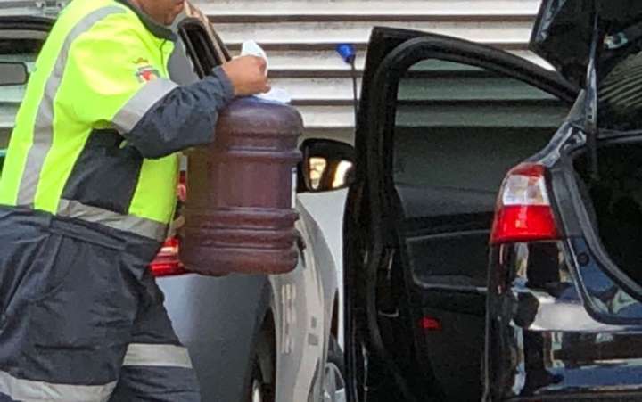 Na cena, um homem aparece levando gasolina em galões de água