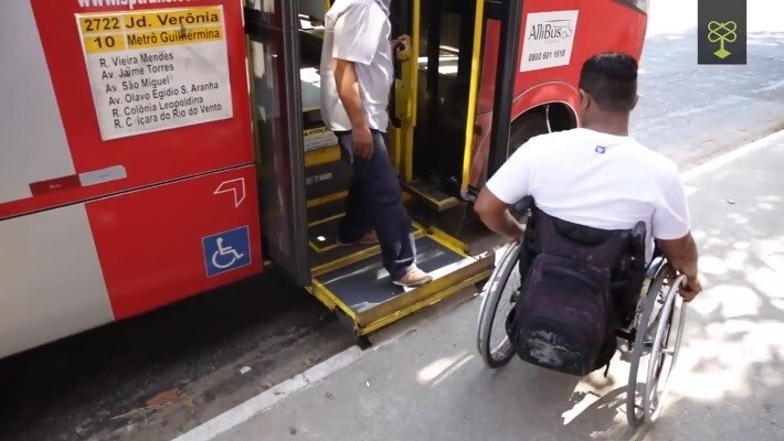 Cadeirante é auxiliado por motorista a subir no ônibus em São Paulo