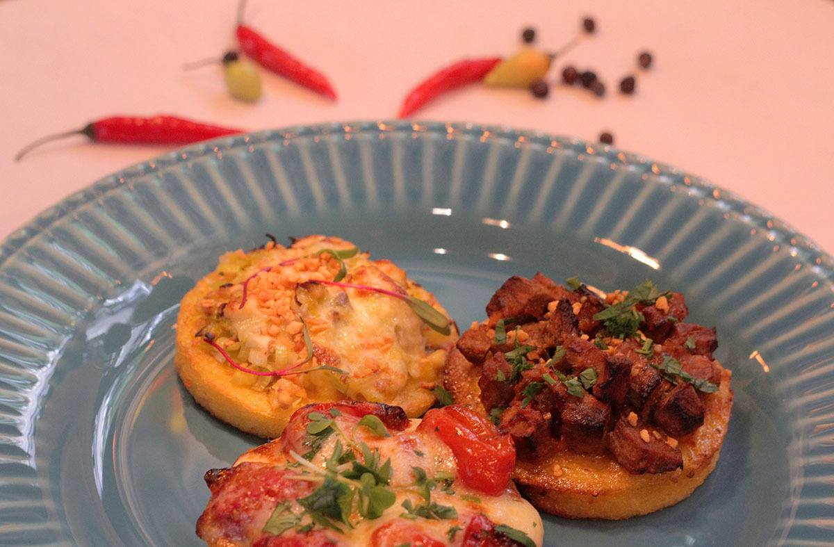 Trio de polenta assada com diferentes coberturas: cogumelo e alho-porró, carne de panela, e caprese