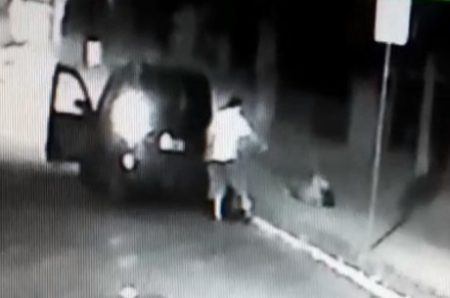 O homem desce do carro e atira contra a mulher caída no chão