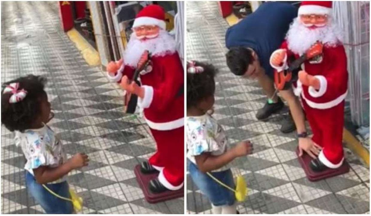 A criança estava dançando em frente ao Papai Noel de brinquedo