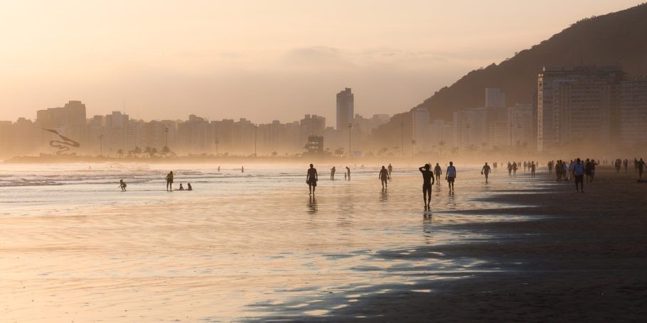 Banhistas caminham em praia de Santos