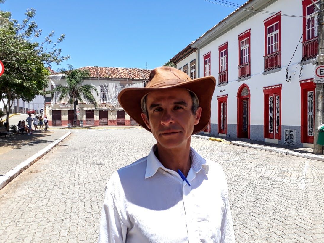 O morador Benedito Gualhardo foi um dos afetados pela enchente. Hoje, gosta de compartilhar com os turistas as histórias da cidade. Ao fundo, casarão em reconstrução