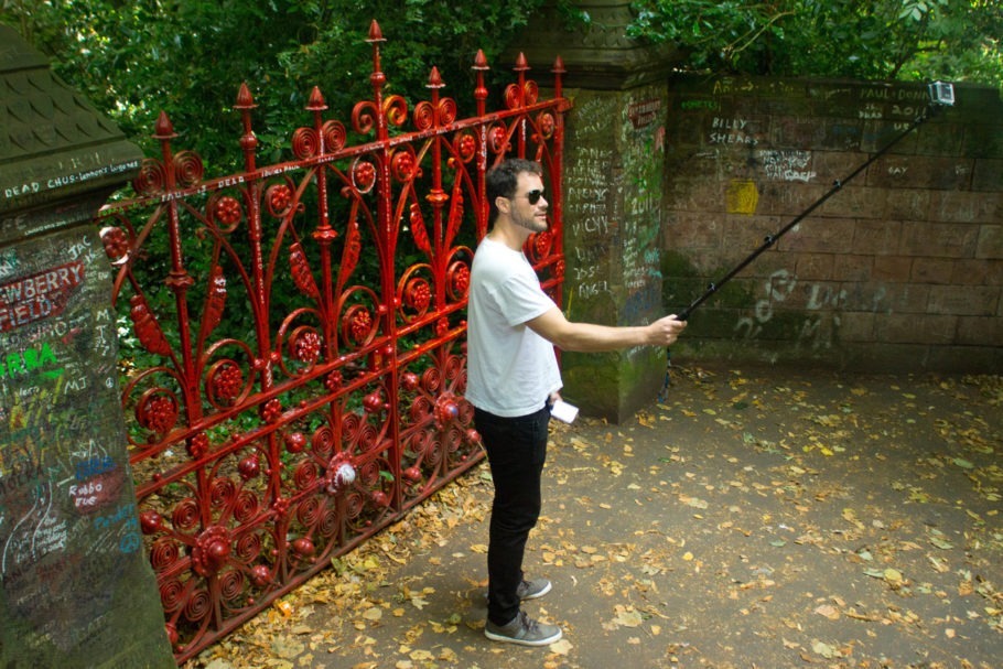 Turista tira selfie em frete ao portão de Strawberry Field, em Liverpool