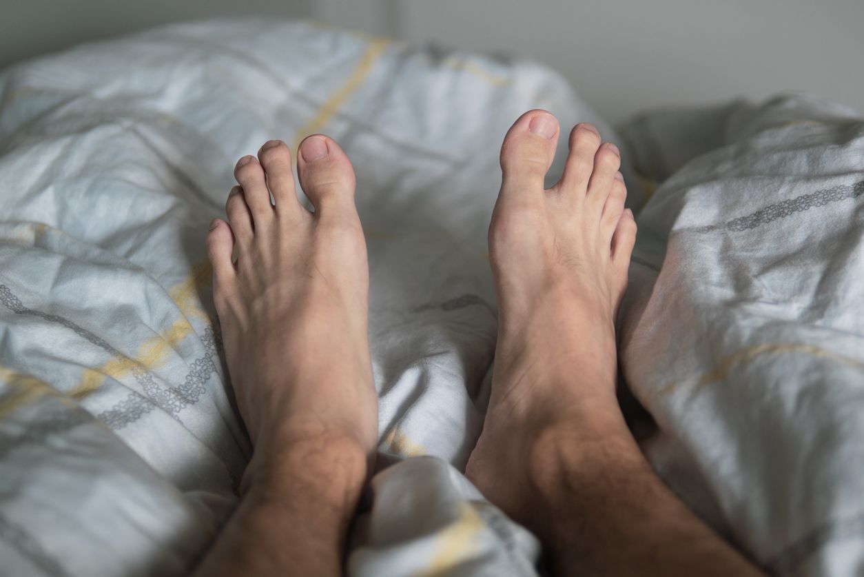 pernas de um homem na cama