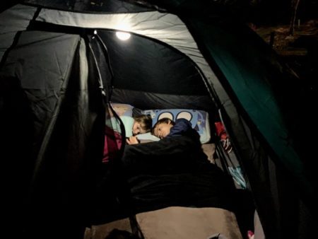 A noite no camping: roupas de cama, travesseiros, mantas e uma lanterna para usar dentro da barraca