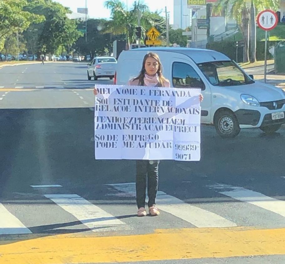 Fernanda Carolina Alves Cabral segura cartaz pedindo emprego na em avenida de Uberlândia