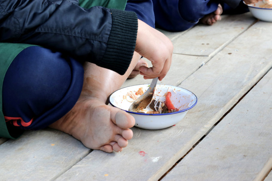criança comendo com o prato no chão
