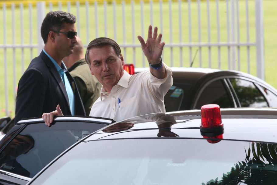 O presidente Jair Bolsonaro cumprimenta populares ao sair do Palácio da Alvorada