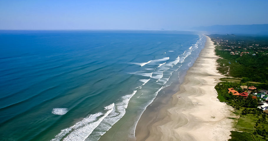 Vista da praia de Guaratuba, tem mar aberto com águas cristalinas, criando um lindo cenário de lazer para a família