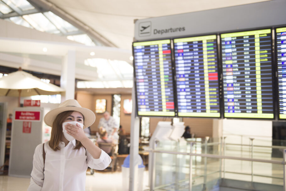 Young Asian tourist woman is putting mask to protect Virus situation in the Airport.