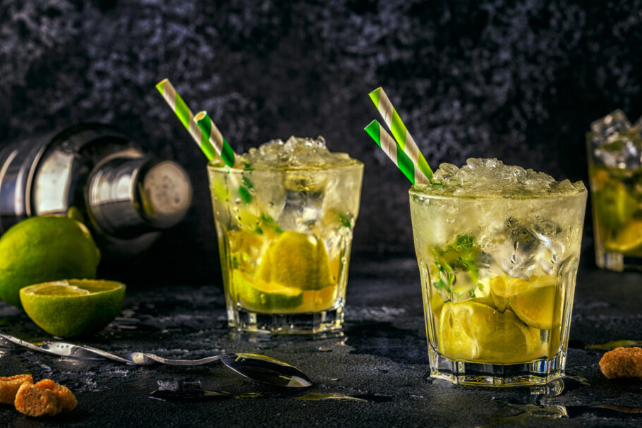Fresh lime cocktail with ice on dark background.