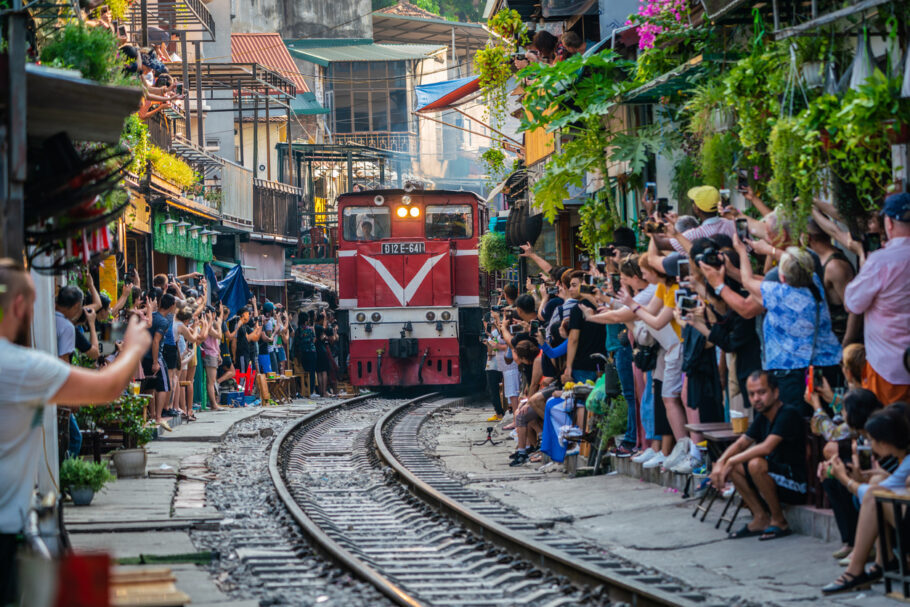 Turistas aguardam trem que passa pontualmente às 15h e às 19h, todos os dias, em uma rua de Hanói (Vietnã)