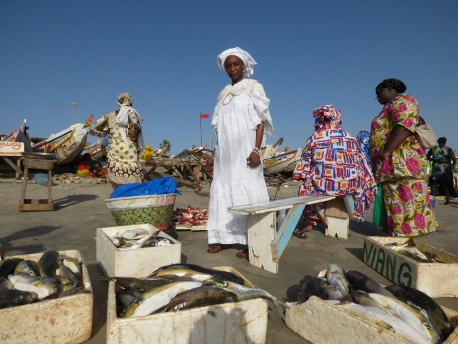  O charme das mulheres cobertas com lenços e vestidos longos demostra a classe natural do povo senegalês com elegância mesmo num porto de pescado.
