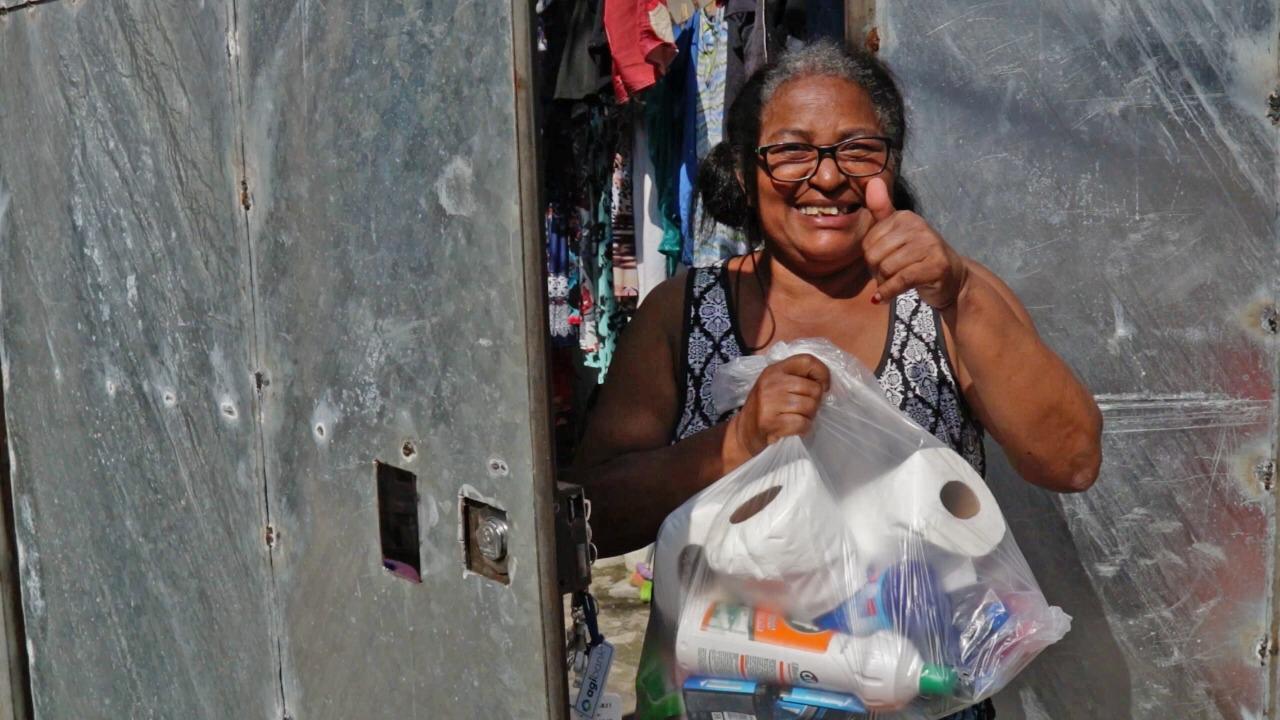 Senhora recebe kit composto por doaçõesm em Heliópolis, na capital paulista