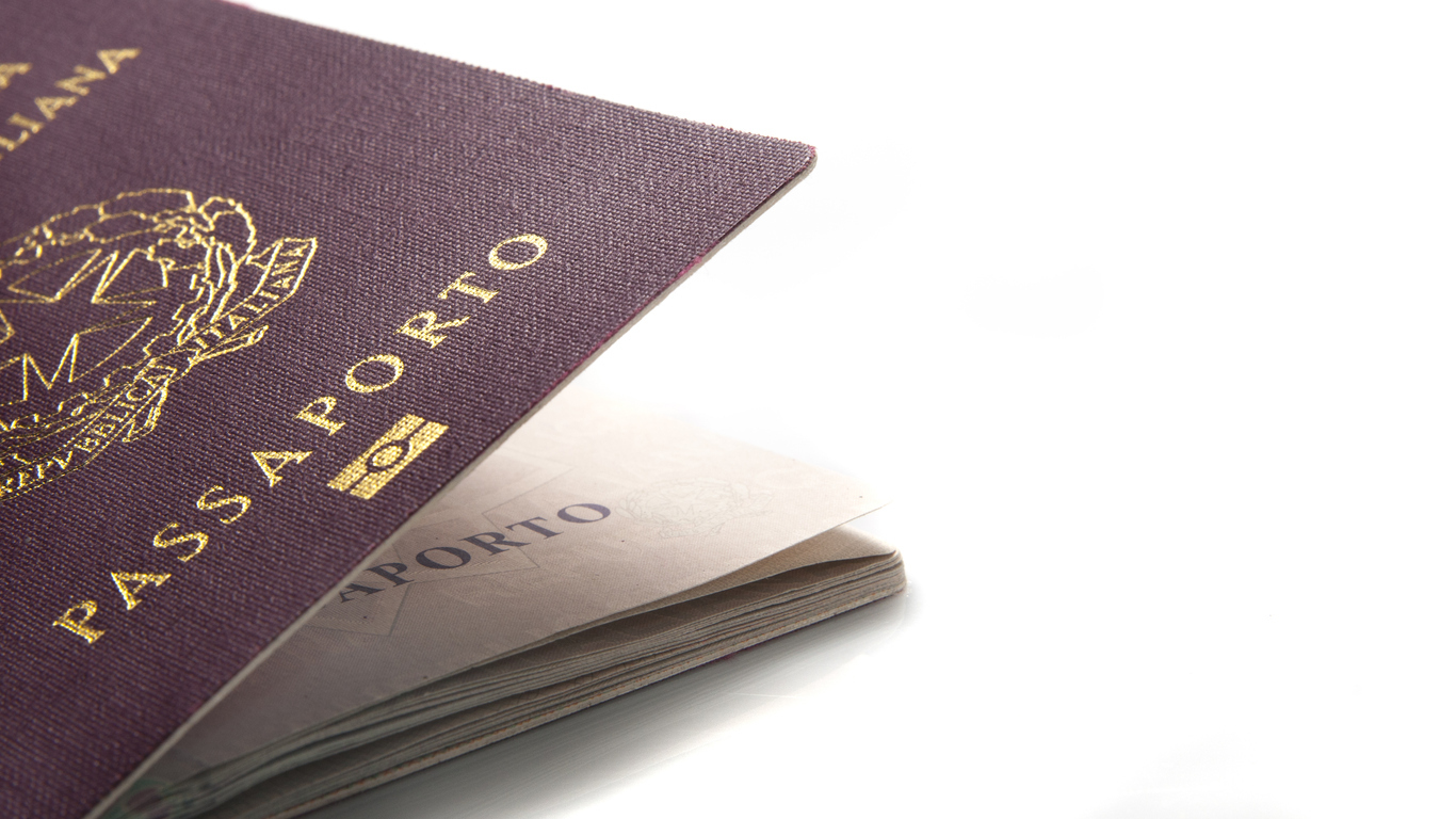 Italian passport slightly open on a white background