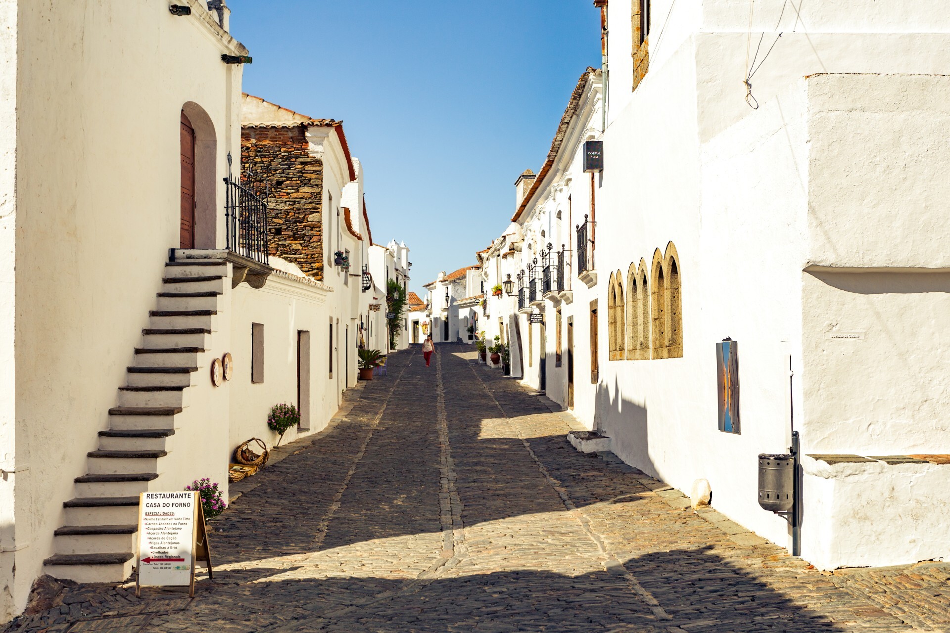 Uma das ruas ruas de pedra e casinhas brancas da pequena vila medieval Monsaraz, no Alentejo