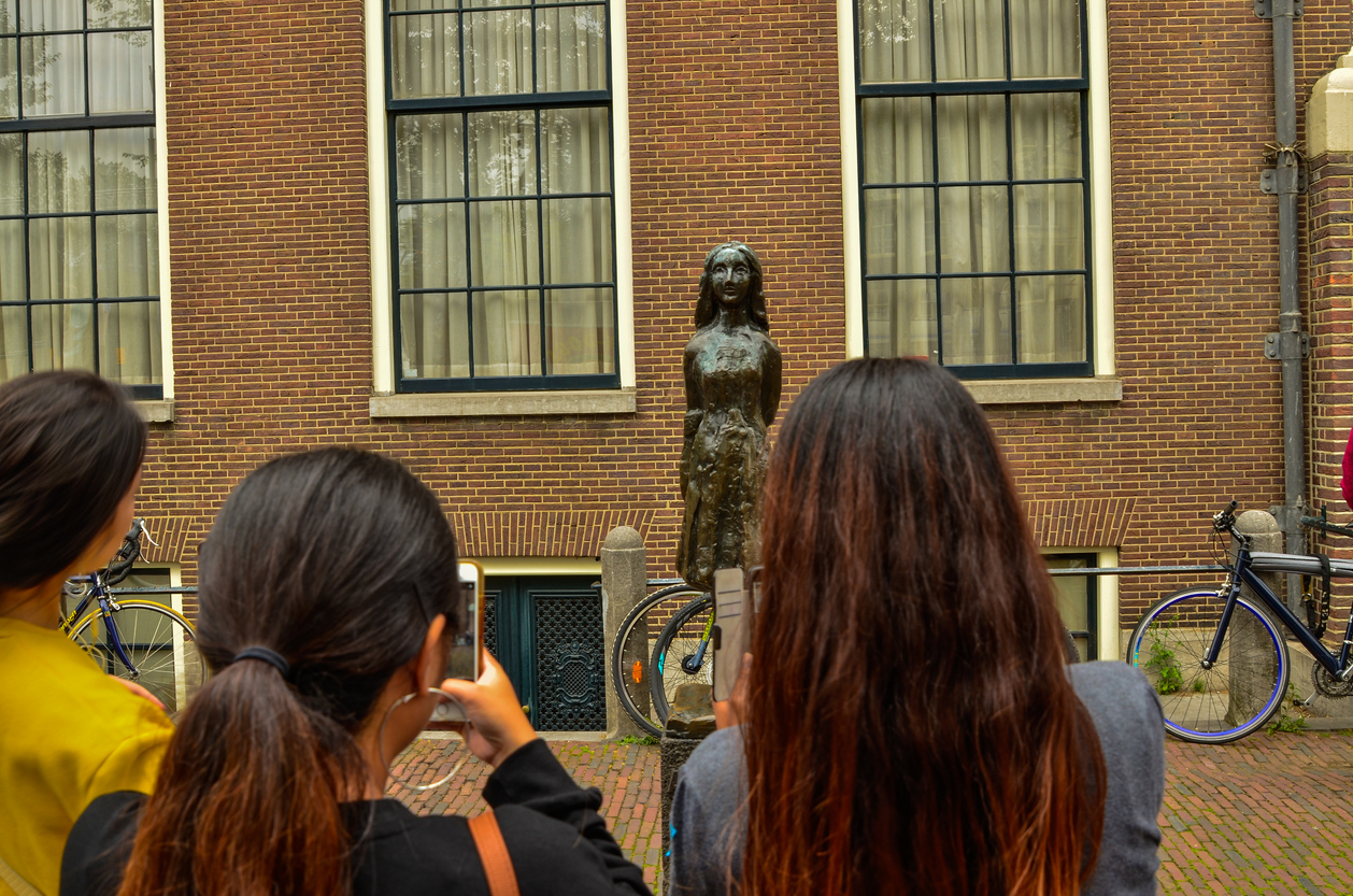 Turistas tiram fotos da estátua de Anne Frank