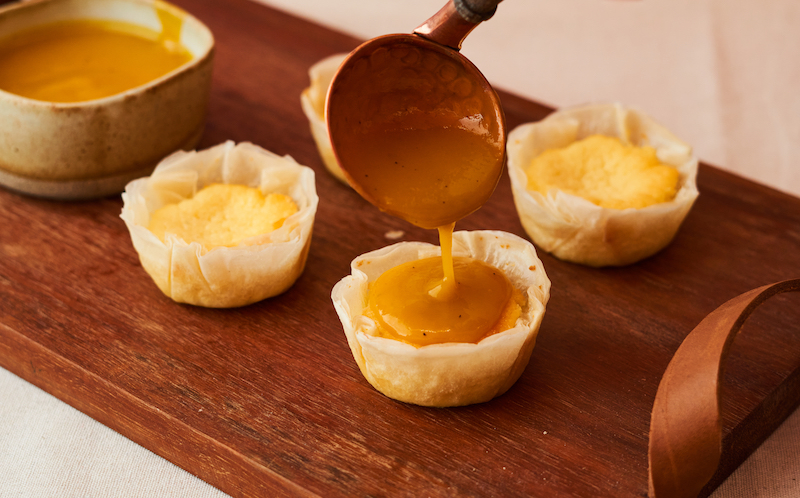 Olha que belezinha essa tortinhas de queijo Boursin na massa filo com calda de manga e maracujá, da confeitaria Marilia Zylbersztajn
