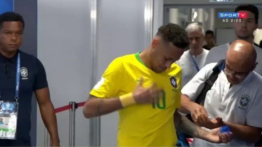 Neymar passa pomada na camisa, na altura do peito, antes do segundo tempo do jogo