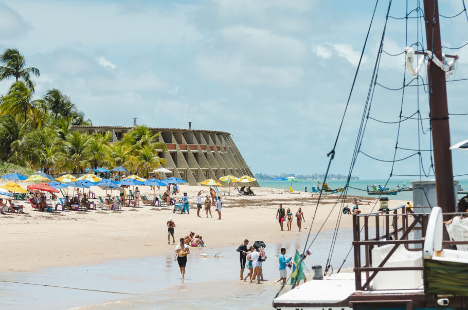 João Pessoa – PB, Brasil – 24 de fevereiro de 2019: Vista da Praia de Tambaú e do icônico Hotel Tambaú ao fundo. Pessoas em um domingo aproveitando a praia mais turística da cidade.