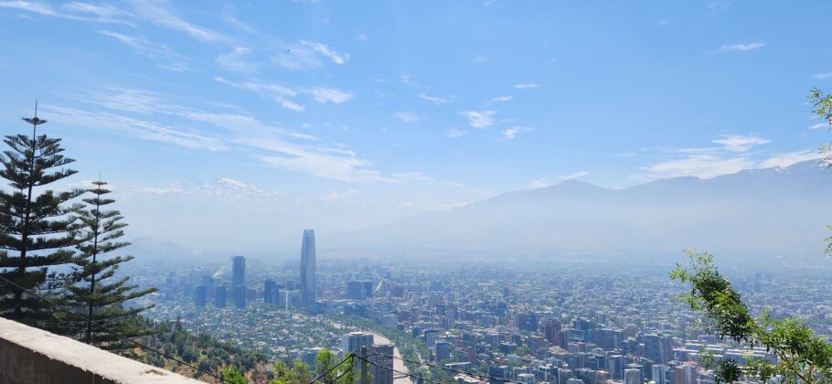 Vista panorâmica de Santiago com os Andes ao fundo e o Sky Costanera à esq.