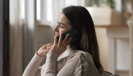 Mulher de cabelo preto aparece sorridente ao falar em uma ligação no WhatsApp