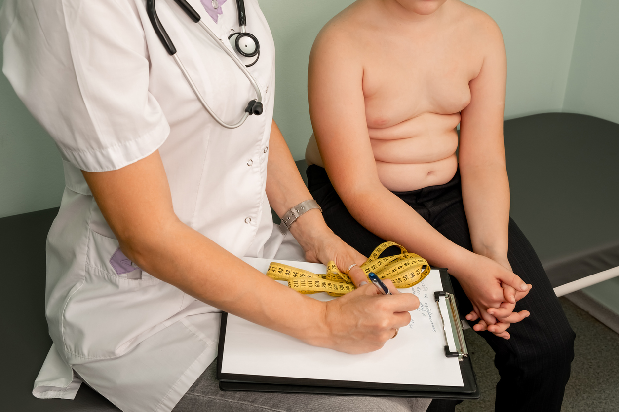 Médica examinando uma criança obesa