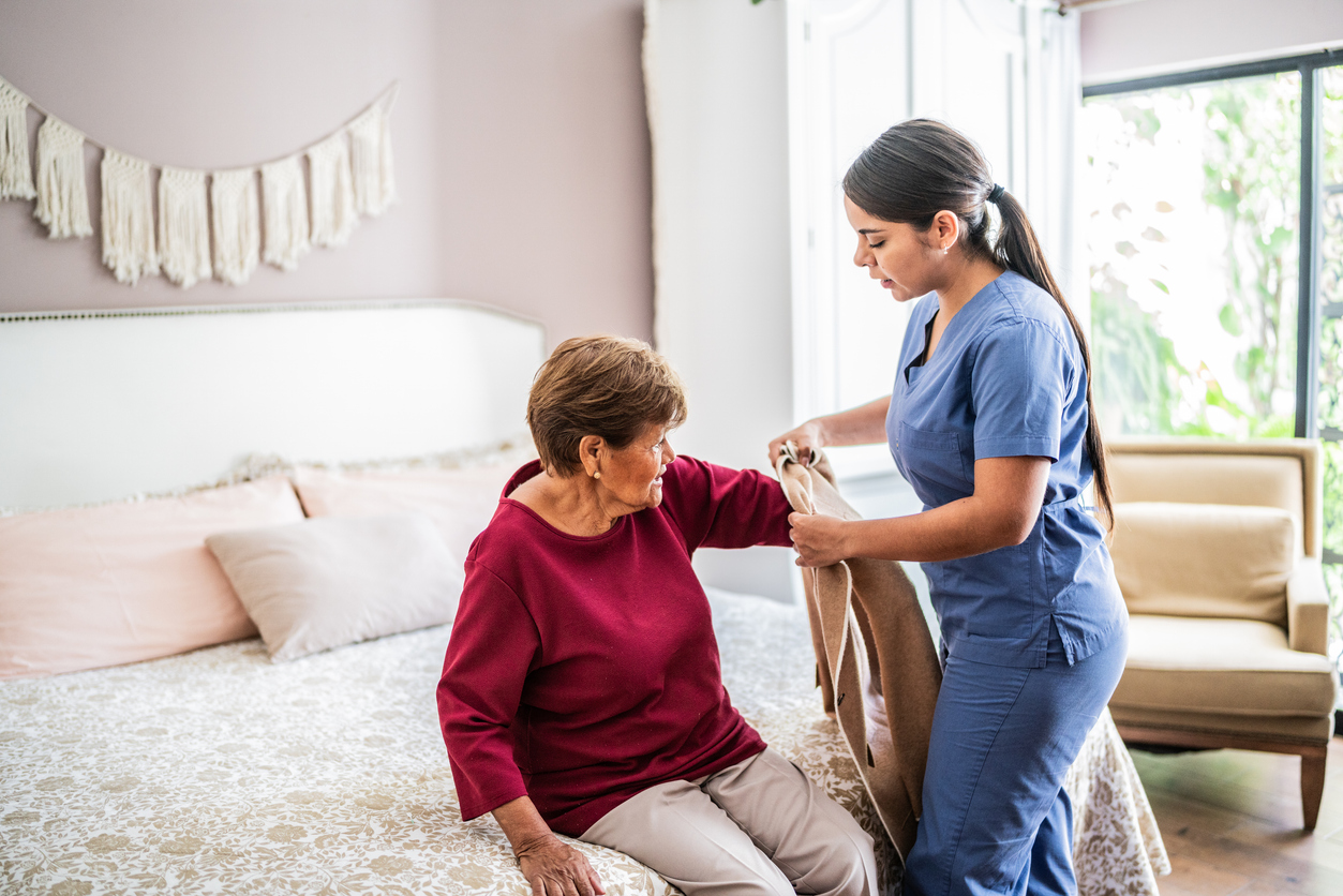 Enfermeira ajudando uma paciente idosa com Parkinson