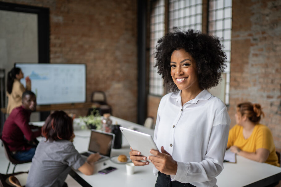 Portrait of a happy businesswoman using digital tablet in a board room