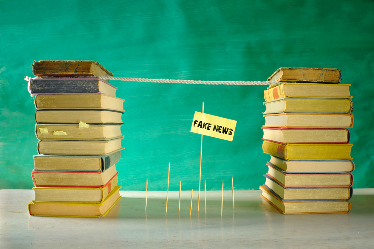 Fight fake news and ignorance, education,learning,knowledge,back to school,media literacy concept with slackline and stacks of books, free copy space