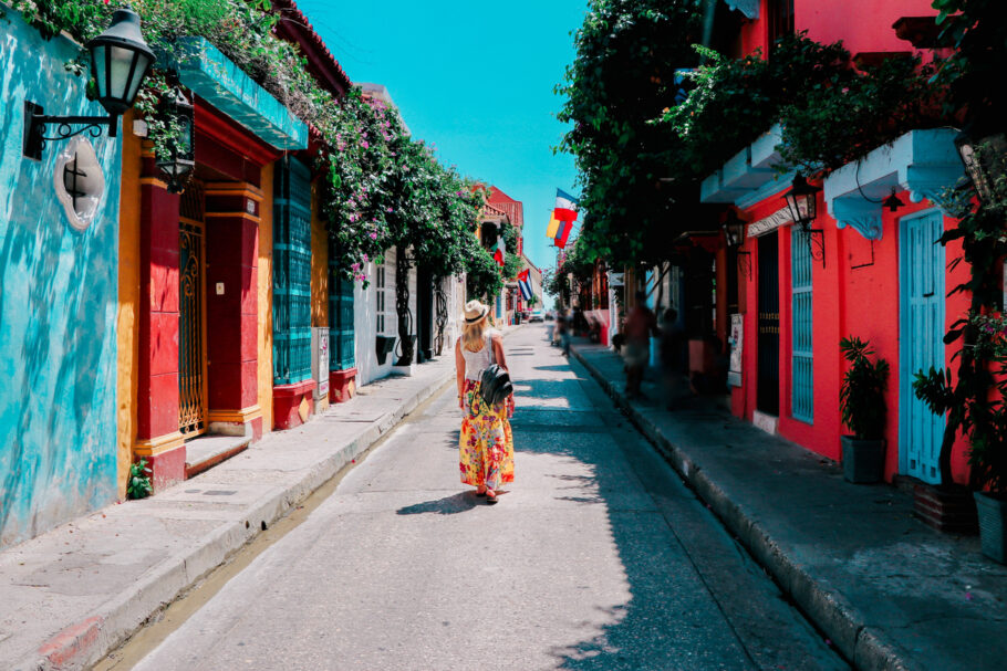 Jovem caminhando em uma rua colorida na cidade velha de Cartagena, Colômbia