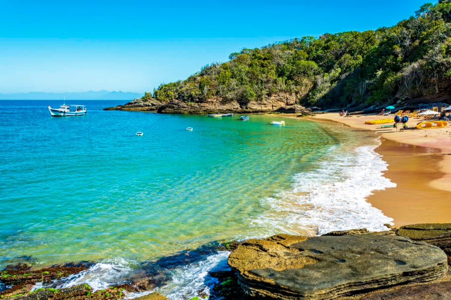 Praia paradisíaca de águas transparentes e coloridas cercada por pedras e vegetação na cidade de Búzios, um dos principais destinos turísticos do Rio de Janeiro